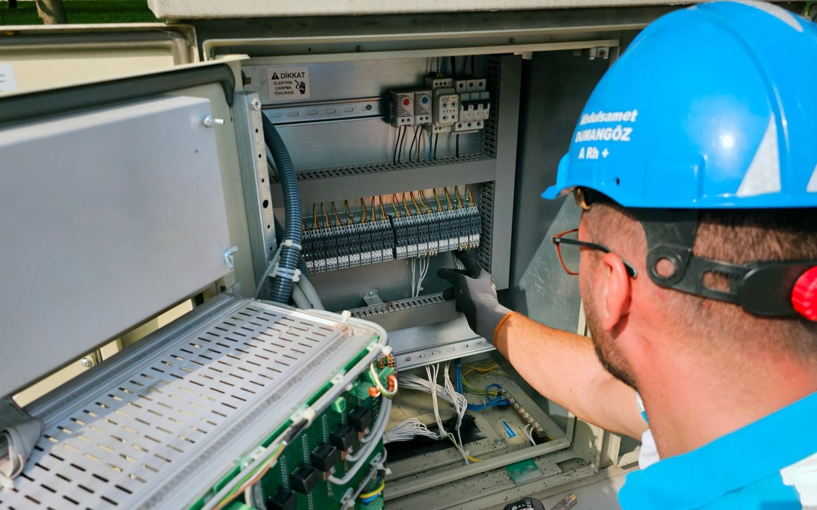 Elektriker arbeitet im geöffneten Schaltschrank an der Verdrahtung
